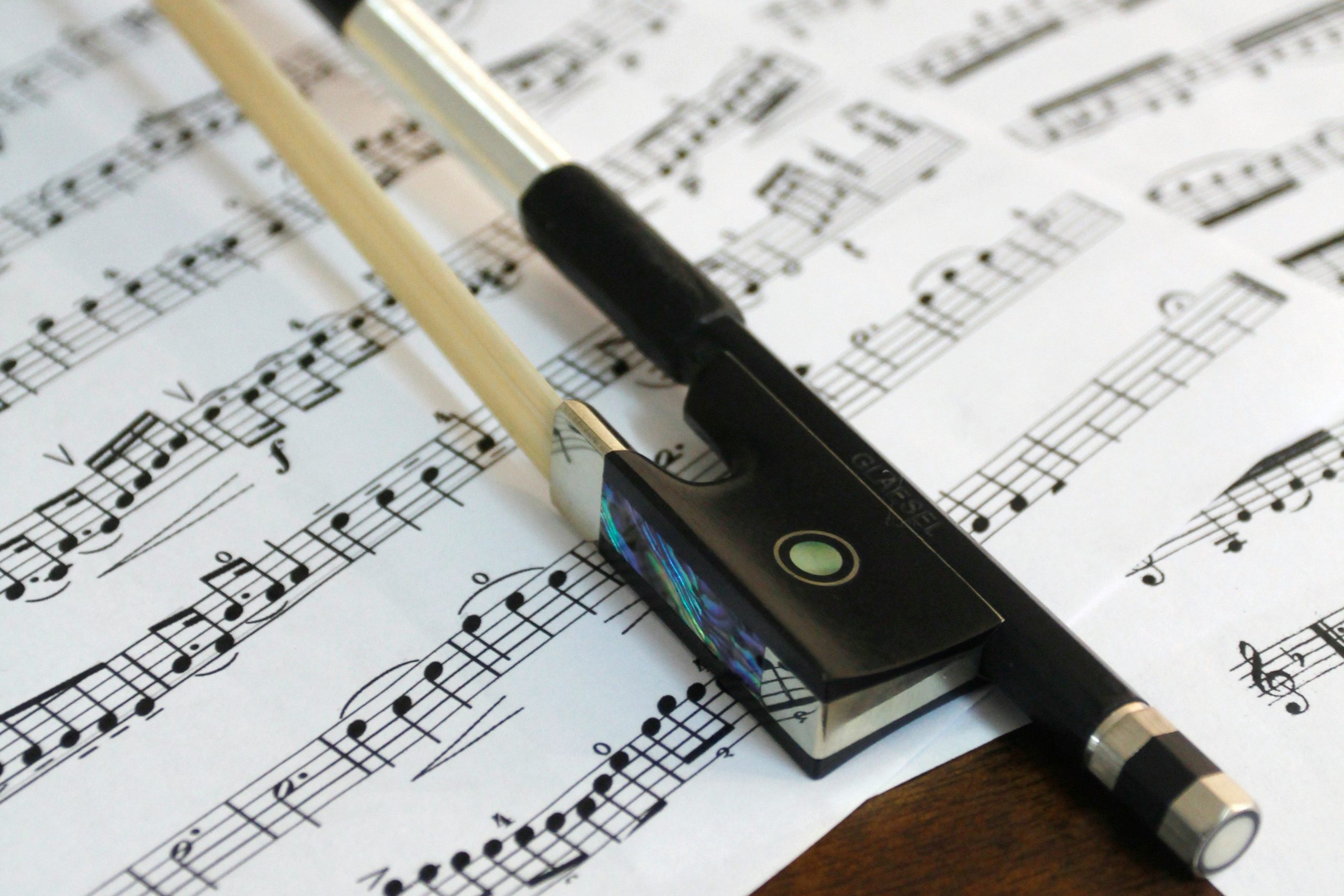 Close up of violin bow resting on sheet music
