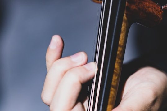 Close up of the violin fingerboard and neck as it is being played